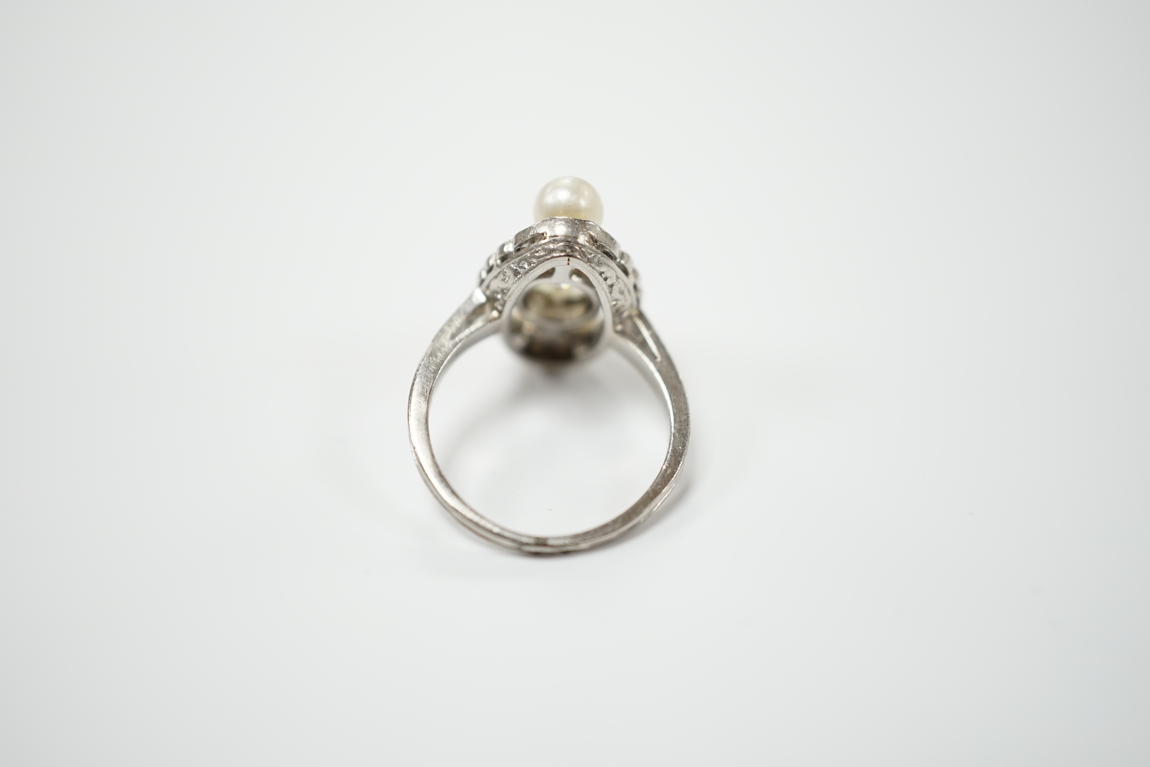 A white metal single stone diamond and two stone cultured pearl set elliptical shaped ring, size F, gross weight 4.3 grams.